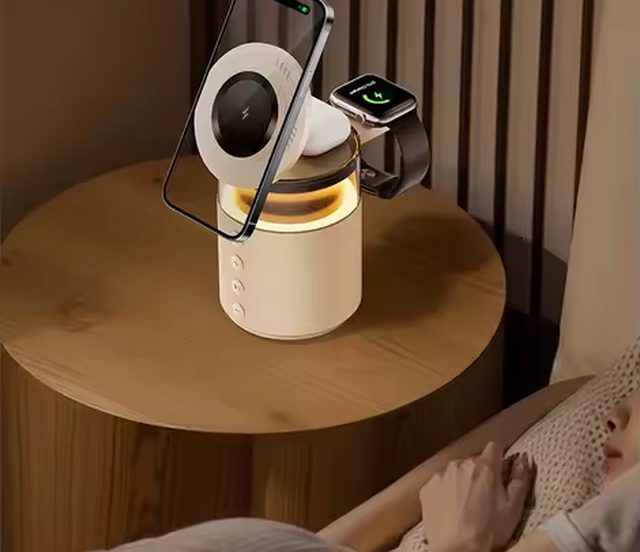 ILENARO sobre una mesilla de noche por la noche, con la luz ambiental cálida encendida mientras carga un móvil y un reloj